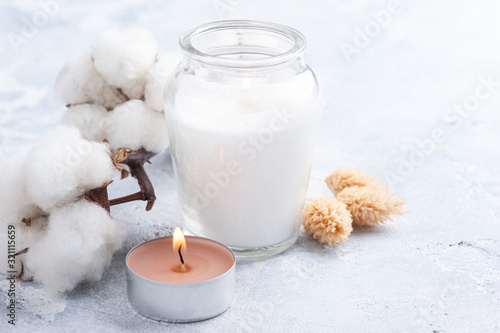 Cotton flower and candle in glas bottle