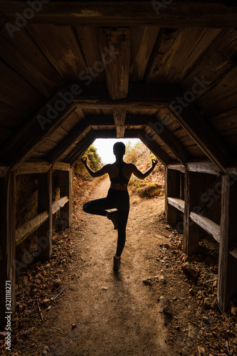 Silhouette of a woman performing a yoga pose in a tunnel in Big Sur California