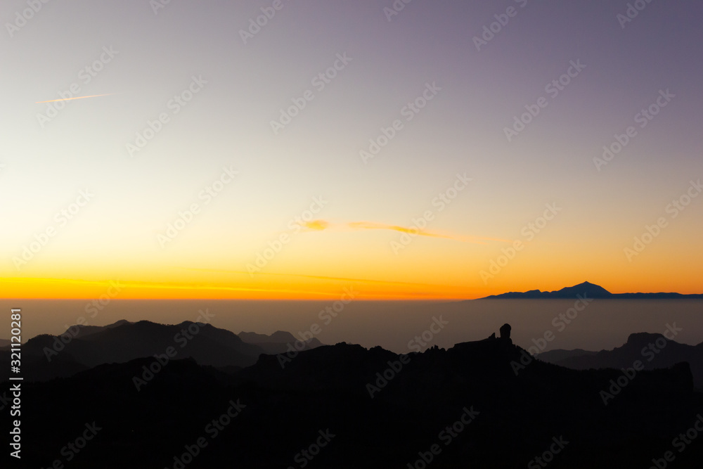 Gorgeous sunset with Teide and Roque Nublo mountains silhouettes in Gran Canaria. Bright twilight at tourist attraction destination in Canary Islands, Spain