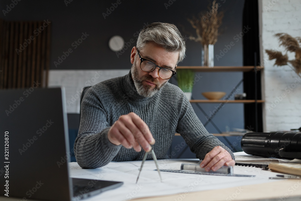 Interior designer working in office with blueprints.Engineer inspect architectural plan, sketching a construction project.Portrait of handsome bearded man at workplace. Business construction concept. Interior designer working in office with blueprints.Engineer inspect architectural plan, sketching a construction project.Portrait of handsome bearded man at workplace. Business construction concept.