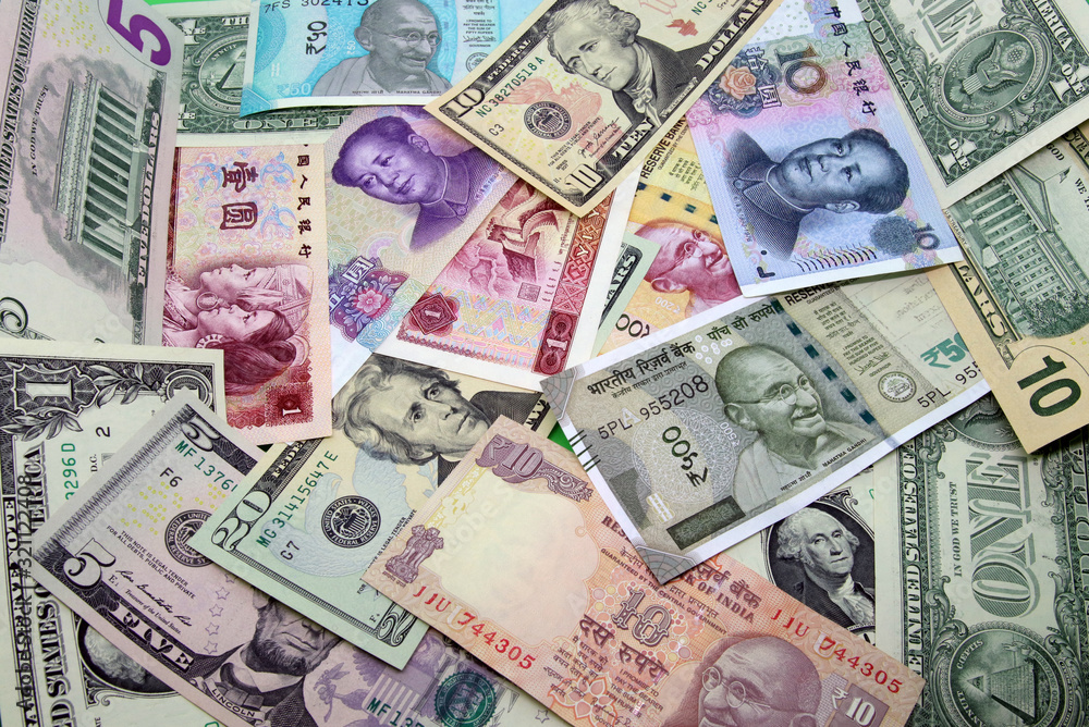 Assorted paper money background. Mix of American, Chinese and Indian colorful banknotes. Assorted paper money background. Mix of American, Chinese and Indian colorful banknotes.