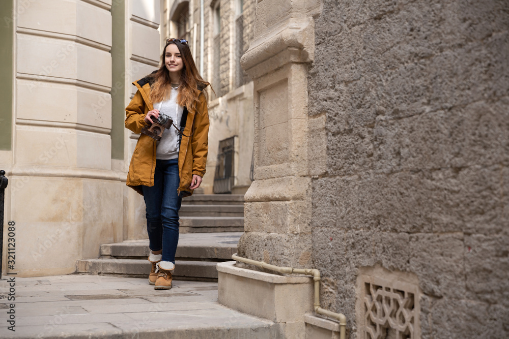 Photo of young tourist girl exploring streets of Baku. Moody photos of teenager girl visiting old city and taking photos of the city Photo of young tourist girl exploring streets of Baku. Moody photos of teenager girl visiting old city and taking photos of the city