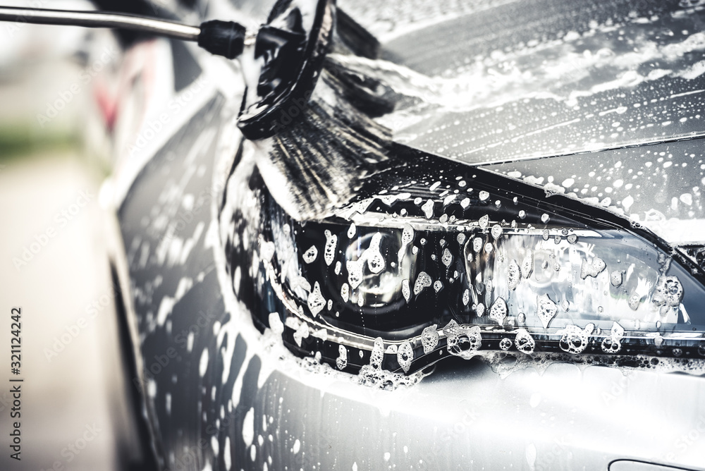 Manual car wash with white soap, foam on the body. Washing Car Using High  Pressure Water. Photos | Adobe Stock