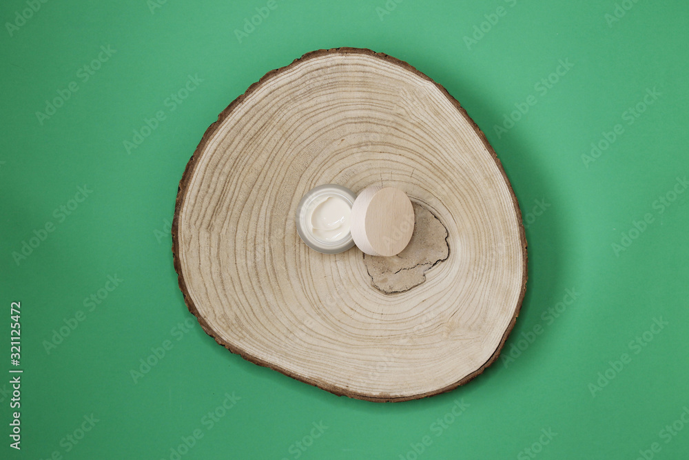 Cream cosmetics items on wooden log Cream cosmetics items on wooden log