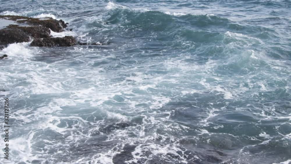 Pan of a wave forming and breaking on rocks Pan of a wave forming and breaking on rocks