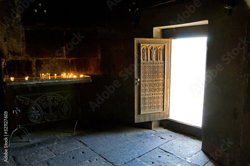 Armenia, Saint Hripsime Church: ornately carved wooden door with sacrificial candles photo