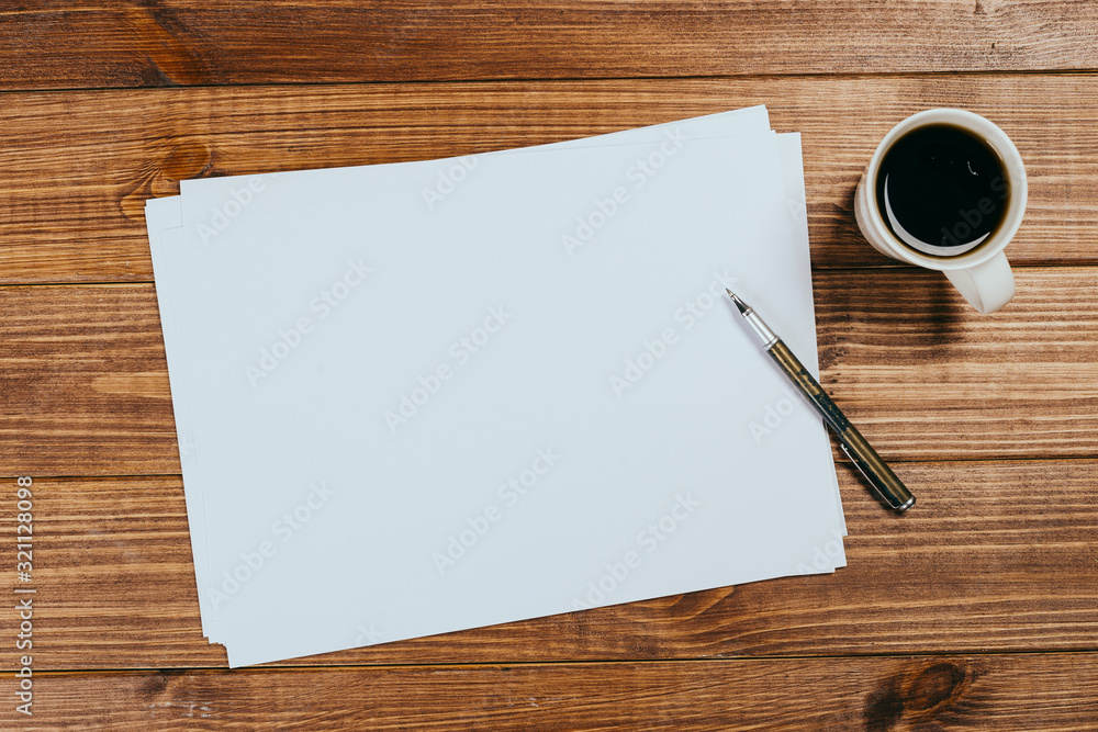 A4 blank paper, cup of coffee on wooden table background. Blank branding template. Photo blank form. Layout for portfolio design. A4 blank paper, cup of coffee on wooden table background. Blank branding template. Photo blank form. Layout for portfolio design.