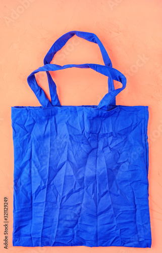 Eco-friendly cotton bag in classic blue color against a peach color background.