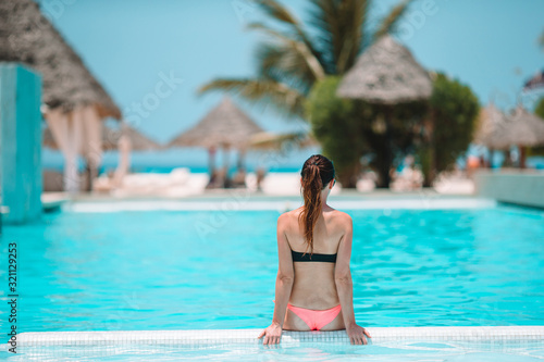 Beautiful young woman relaxing in swimming pool. © travnikovstudio