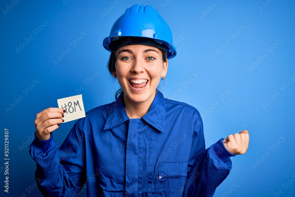 Beautiful worker woman wearing hardhat and uniform celebrating 8th march womens day screaming proud and celebrating victory and success very excited, cheering emotion Beautiful worker woman wearing hardhat and uniform celebrating 8th march womens day screaming proud and celebrating victory and success very excited, cheering emotion