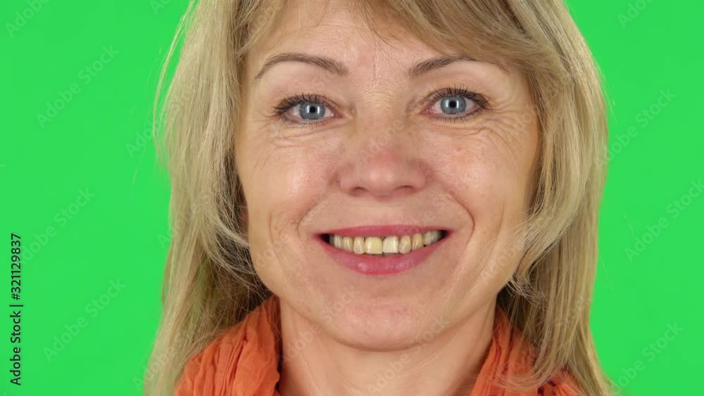 Middle aged blonde woman smiling while looking at the camera. Close-up. Green screen Middle aged blonde woman smiling while looking at the camera. Close-up. Green screen