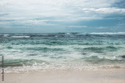 Sea beach surf waves turquoise water blue dramatic overcast sky landscape 