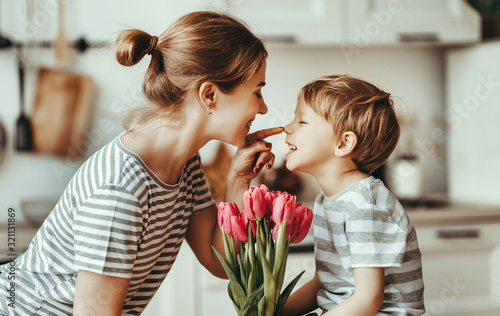 happy mother's day! child son gives flowers for  mother on holiday . photo