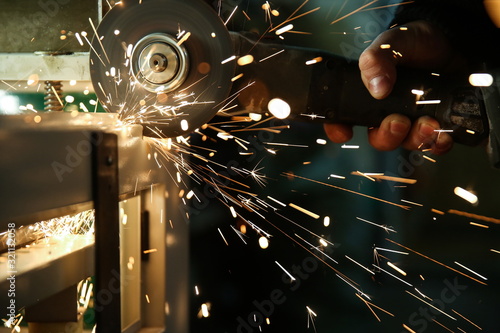angle grinder is cutting metal with sparks close up