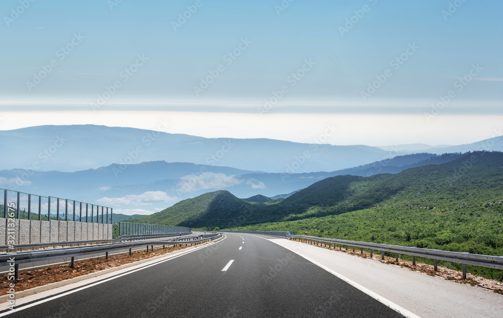 Mountain highway with blue sky and rocky mountains on a background.