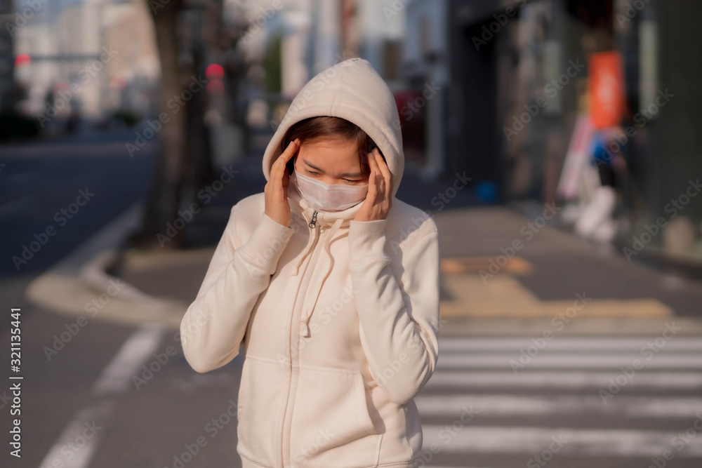 Fototapeta premium 屋外でマスクをしている若い女性