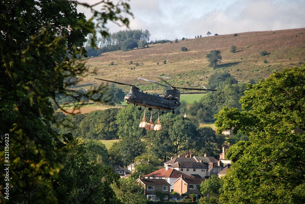 Chinook helicopter carrying bags of ballast in Whaley Bridge, Peak District
