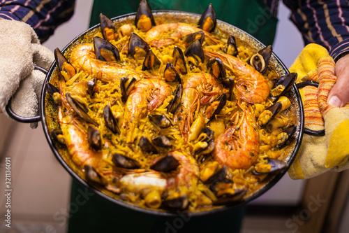 Fideua of seafood with prawns and mussels in paella and cook showing the typical food of Valencia in Spain. photo