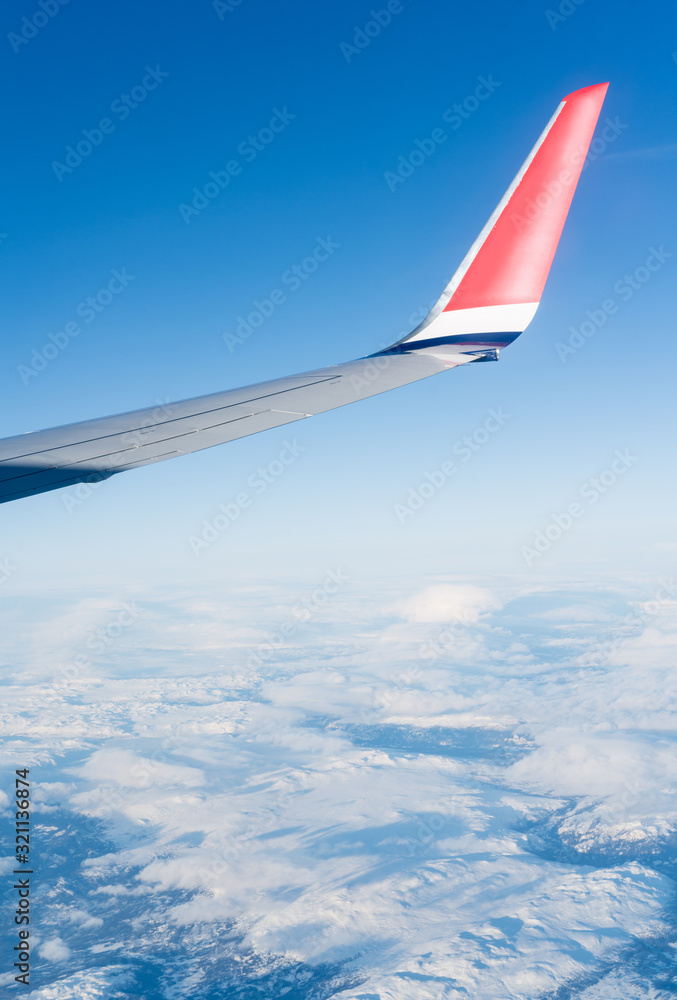 Fototapeta premium Wing aircraft in blue clear sky during flight