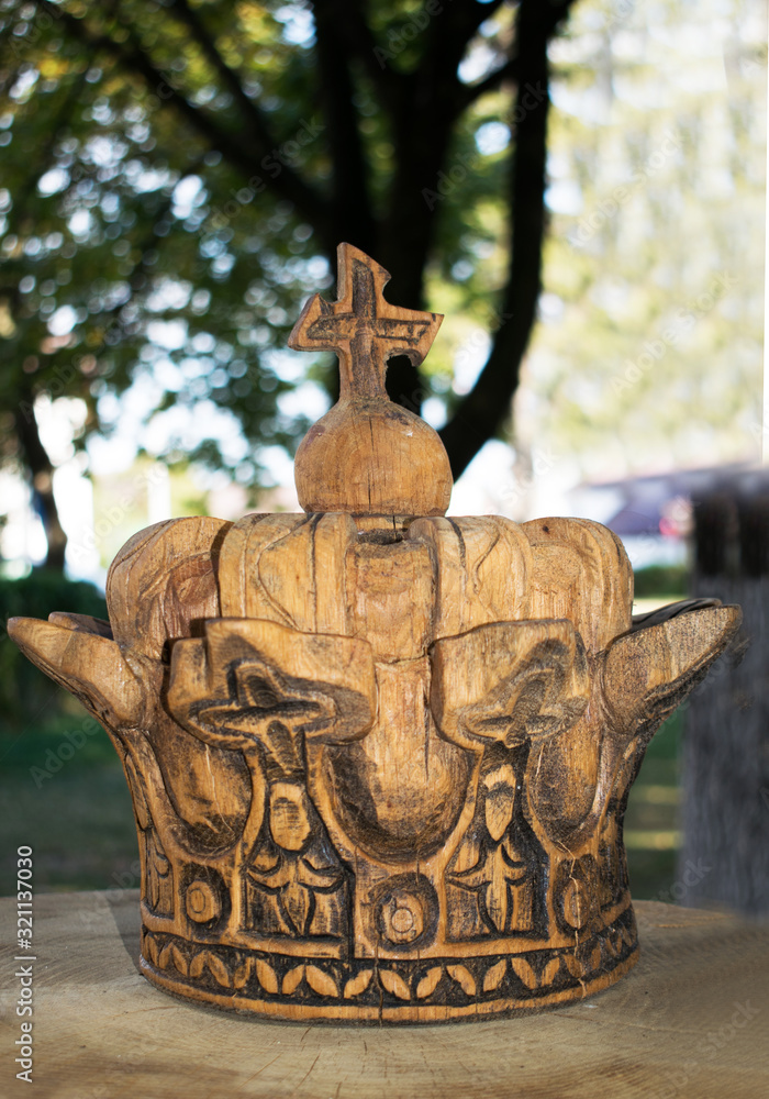 Royal crown carved in wood. It is part of a larger piece located in a park. Romania, Bran. September, 22, 2019