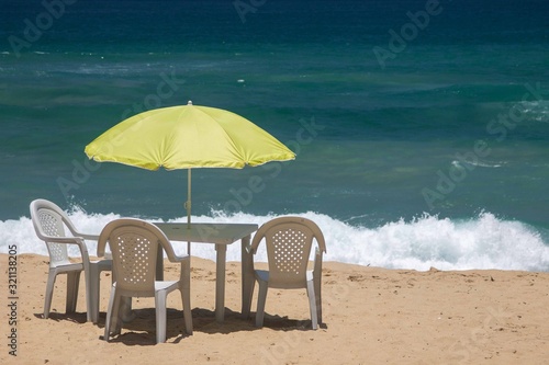 A green umbrella and chairs on the Sono's beach in Paraty, Rio de Janeiro, Brazil photo