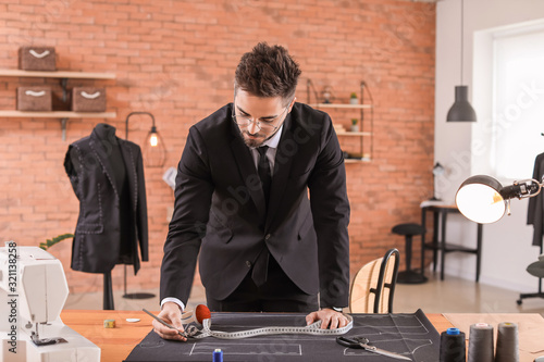 Young tailor working at tab...