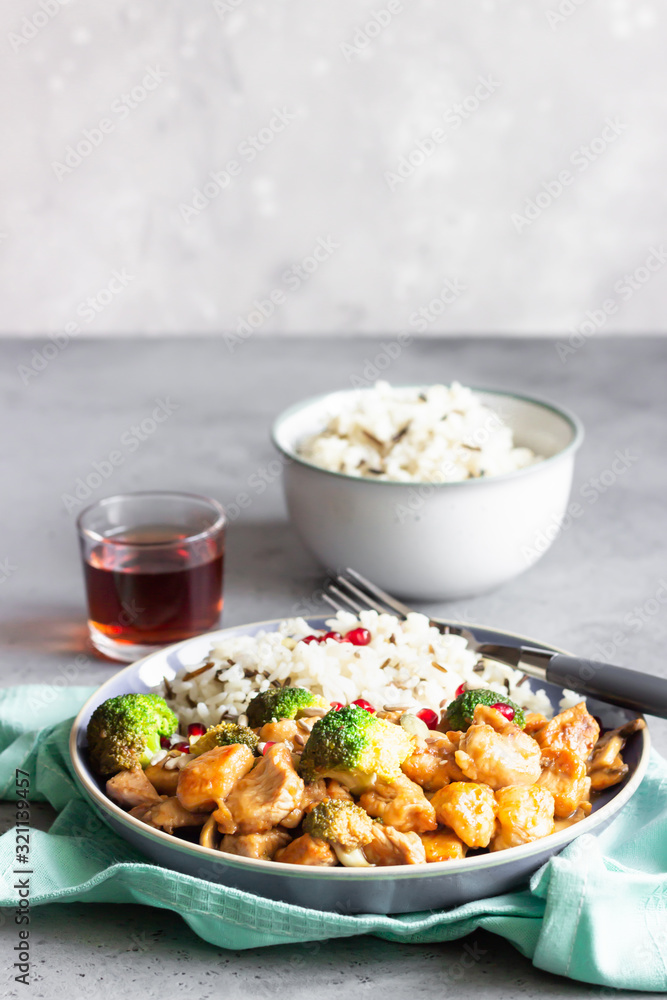 Curry chicken with rice, mushroom and broccoli decorated with pomegranate seeds. Healthy food. Asian cuisine. Curry chicken with rice, mushroom and broccoli decorated with pomegranate seeds. Healthy food. Asian cuisine.