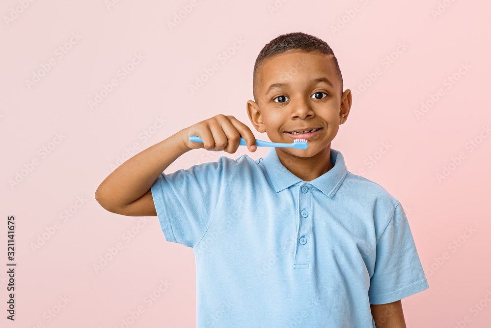 Little African-American boy with tooth brush on color background Little African-American boy with tooth brush on color background