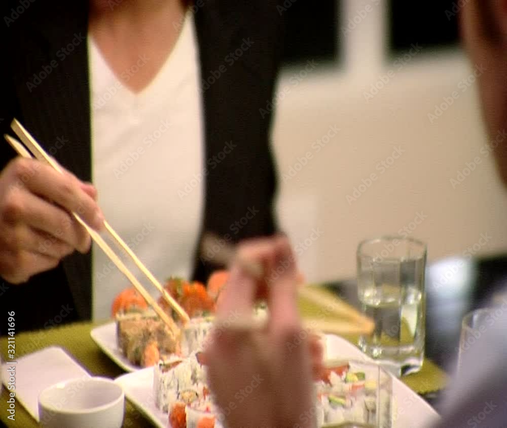 TU, CU, Selective Focus, Over the Shoulder View, A man eating sushi with a friend TU, CU, Selective Focus, Over the Shoulder View, A man eating sushi with a friend