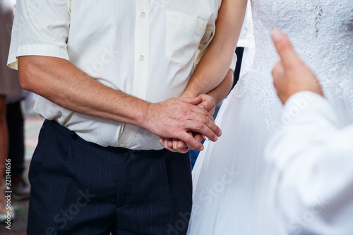 Bride and groom hold hands on wedding day © Дмитрий Ткачук