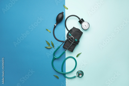 Stethoscope with sphygmomanometer on color background photo