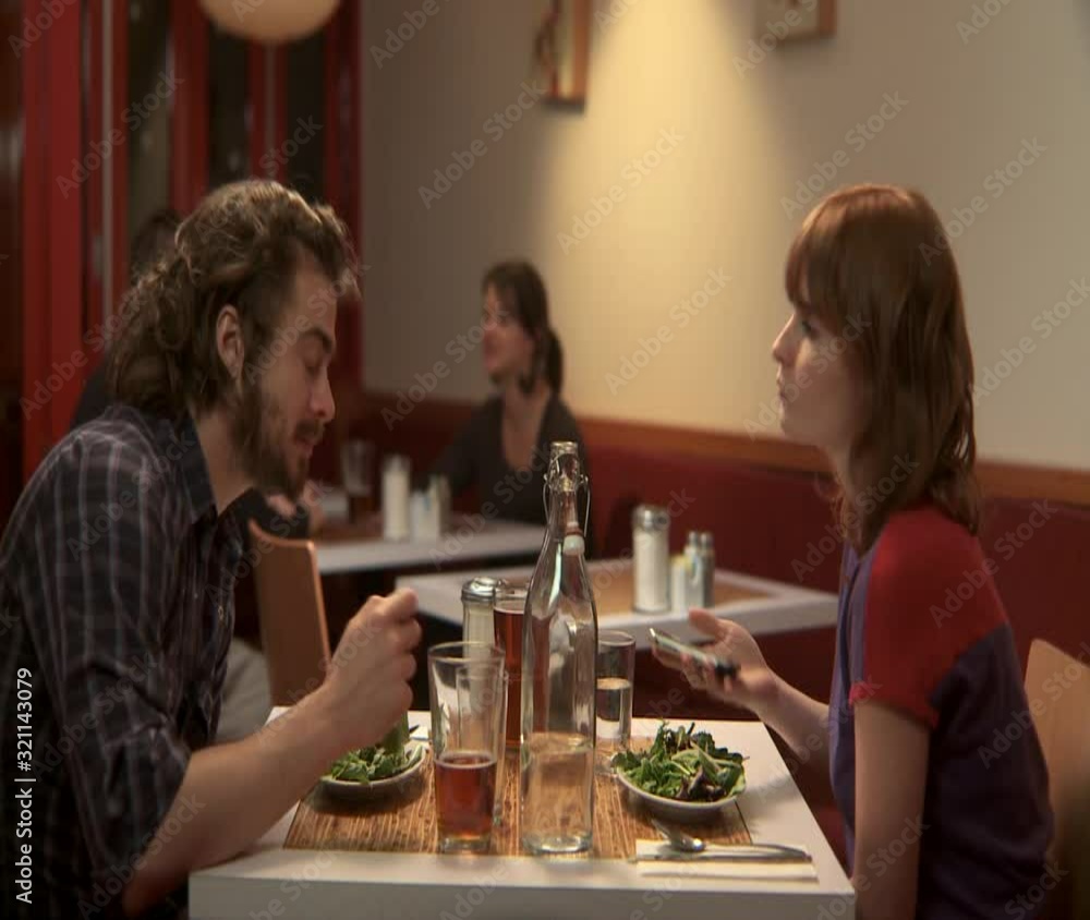 MS, Lockdown, Focus on Foreground, A man and a woman in a cafe when the woman receives an SMS MS, Lockdown, Focus on Foreground, A man and a woman in a cafe when the woman receives an SMS