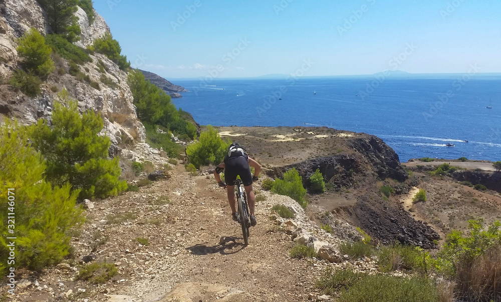 ragazzo scende discesa in velocità con la sua bicicletta su un'isola