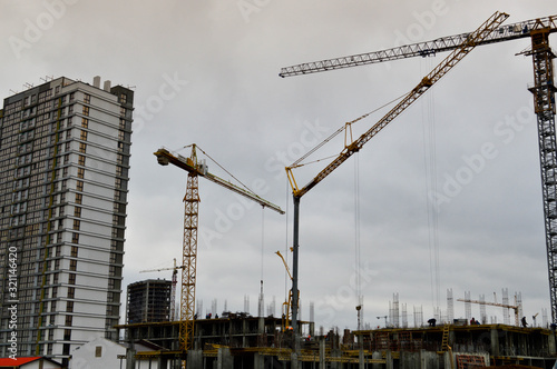 Construction of large modern monolithic frame houses, buildings using industrial construction equipment and large high cranes. Construction of the building in the new micro district of the city photo