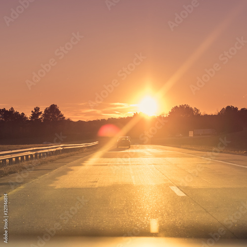 Sunset on a Highway with Car in Empty Lane