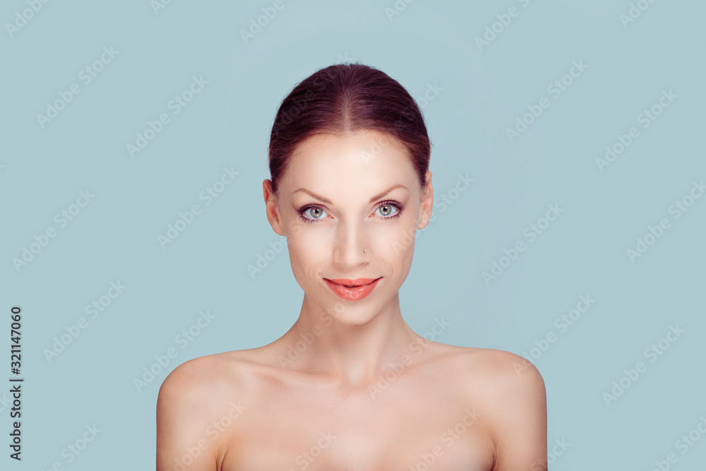 Beauty with flawless skin. Natural brunette model posing smiling looking at camera on light blue white background. Beauty with flawless skin. Natural brunette model posing smiling looking at camera on light blue white background.