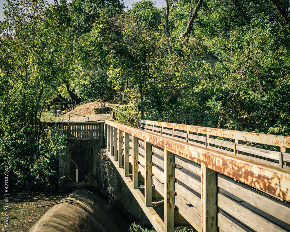 Fototapeta premium Wooden Bridge Walkway over a Dam in a Park
