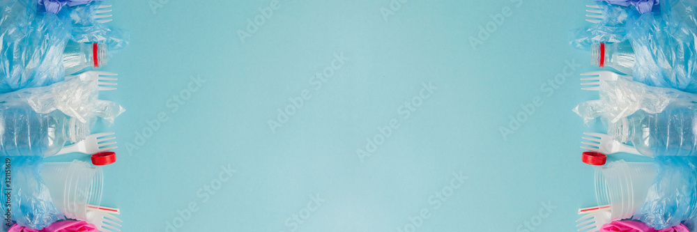Top view of various kinds of disposable plastic waste on blue background, copy space Top view of various kinds of disposable plastic waste on blue background, copy space