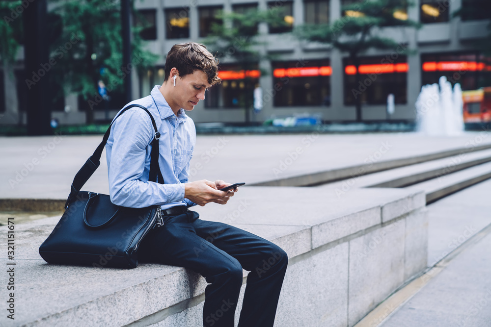 Male emploee messaging on phone on street Male emploee messaging on phone on street