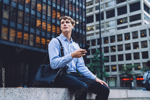 Young man messaging on phone on urban background