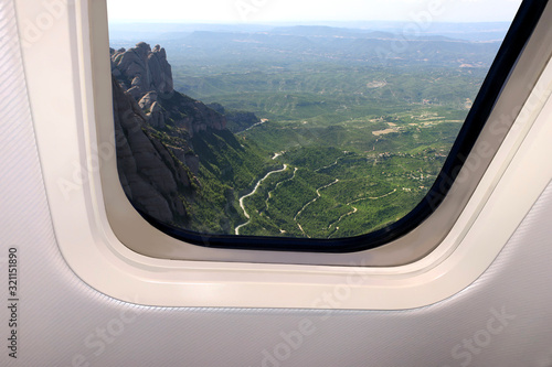beautiful sky blue sky landscape with clouds and views of the earth below behind the porthole of a plane, travel concept