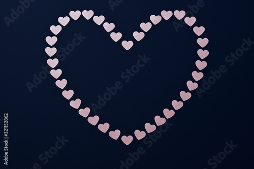 Heart of pink Valentines on a dark blue background for a greeting card with space for text on Valentine's day.