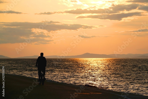 Unrecognizable man driving a bicycle at sunset in Sutivan, Brac island, Croatia. Selective focus.