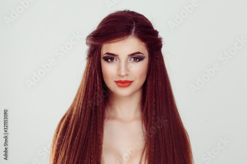Beauty girl woman with long hair looking at you camera slightly smiling isolated white gray background. Full makeup brunette brown hair, red lips