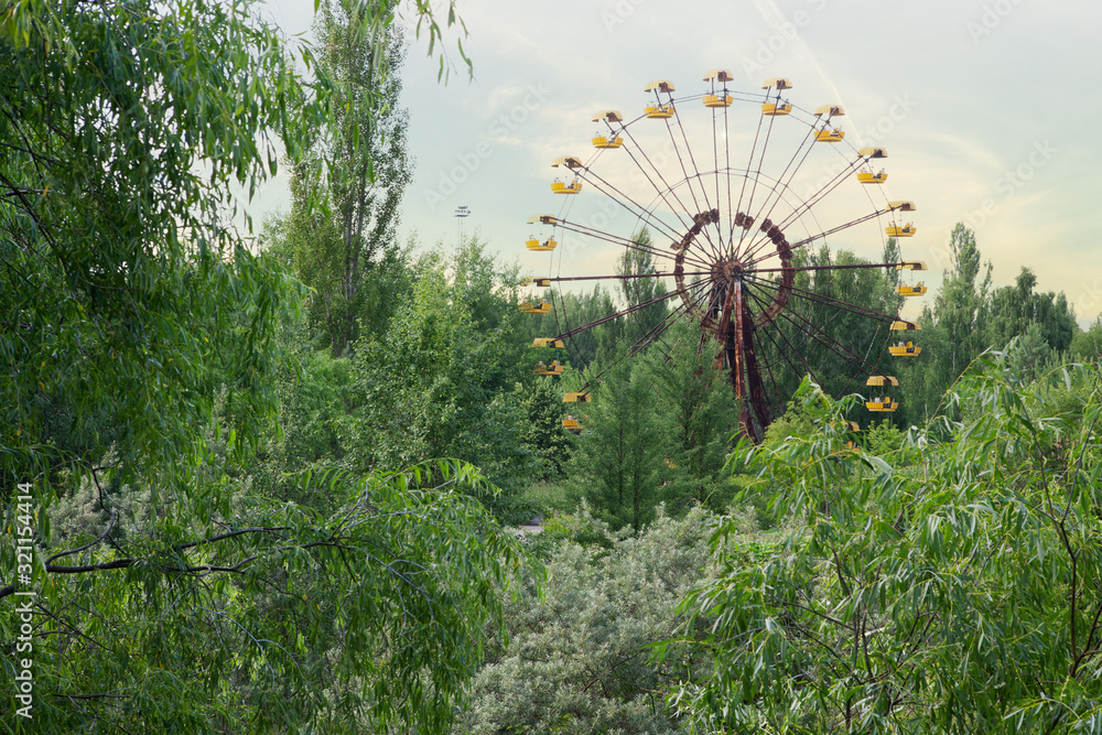 Fototapeta premium Big wheel in Ghost City of Pripyat exclusion Zone of Chernobyl accident dominates the energy of most disastrous nuclear power plant accide