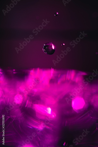 Water drop splashing pink abstract background
