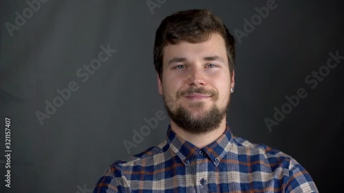 A smiling male in a plaid shirt in the studio  photo