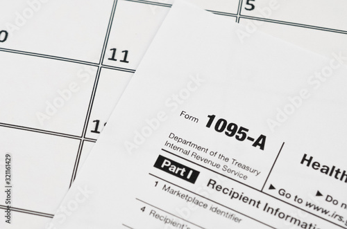 IRS Form 1095-A Health Insurance Marketplace Statement tax blank lies on empty calendar page photo