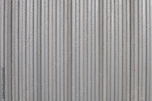 metal sheets next to each other form the foundation for a metal gate or fence. Structure for background or wallpaper