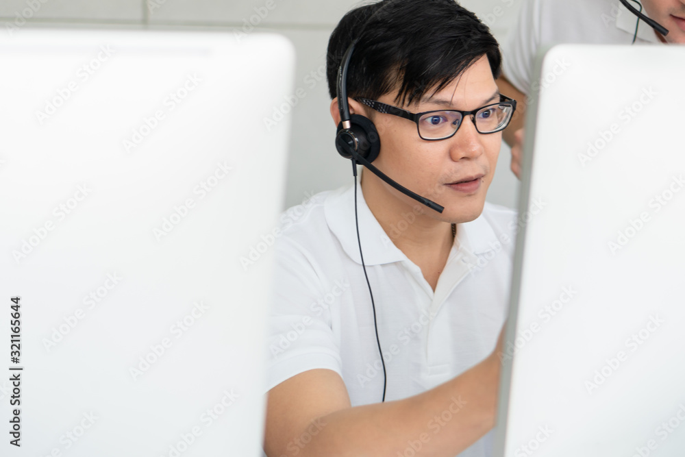 business background of asian male customer service agent on telephone service to customers at helpdesk call center business background of asian male customer service agent on telephone service to customers at helpdesk call center